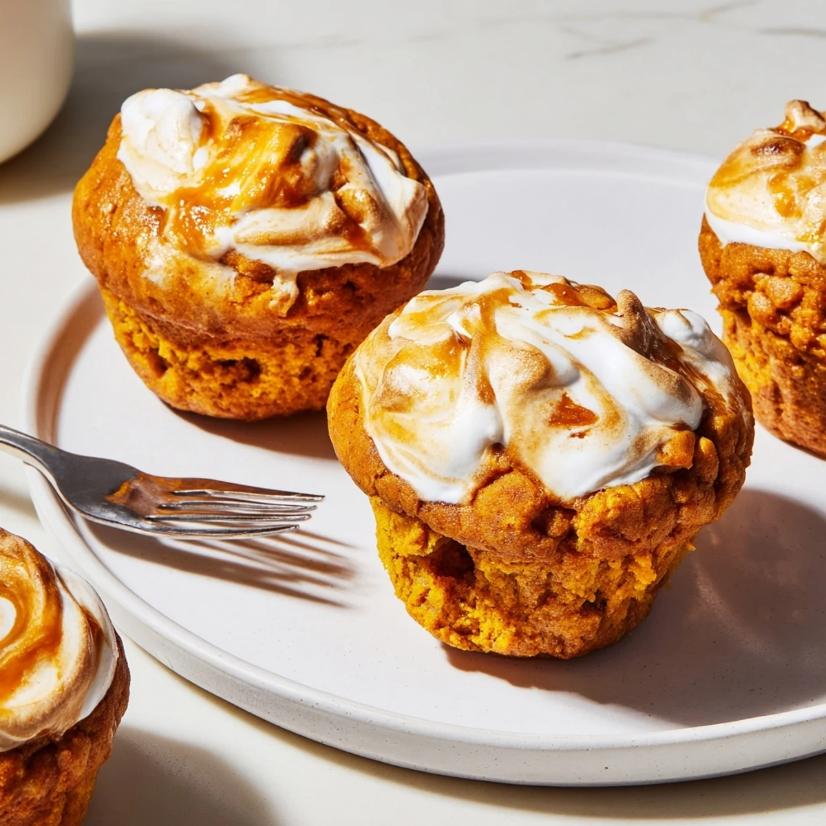 Moist pumpkin muffins with a delightful marshmallow swirl, perfect for cozy fall mornings.  
