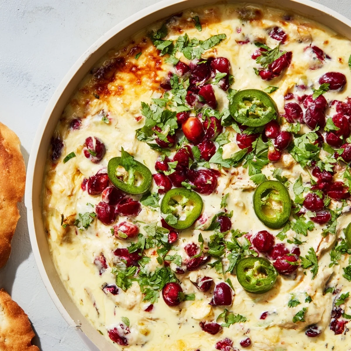 Creamy cranberry jalapeño queso dip served warm with crispy tortilla chips.  