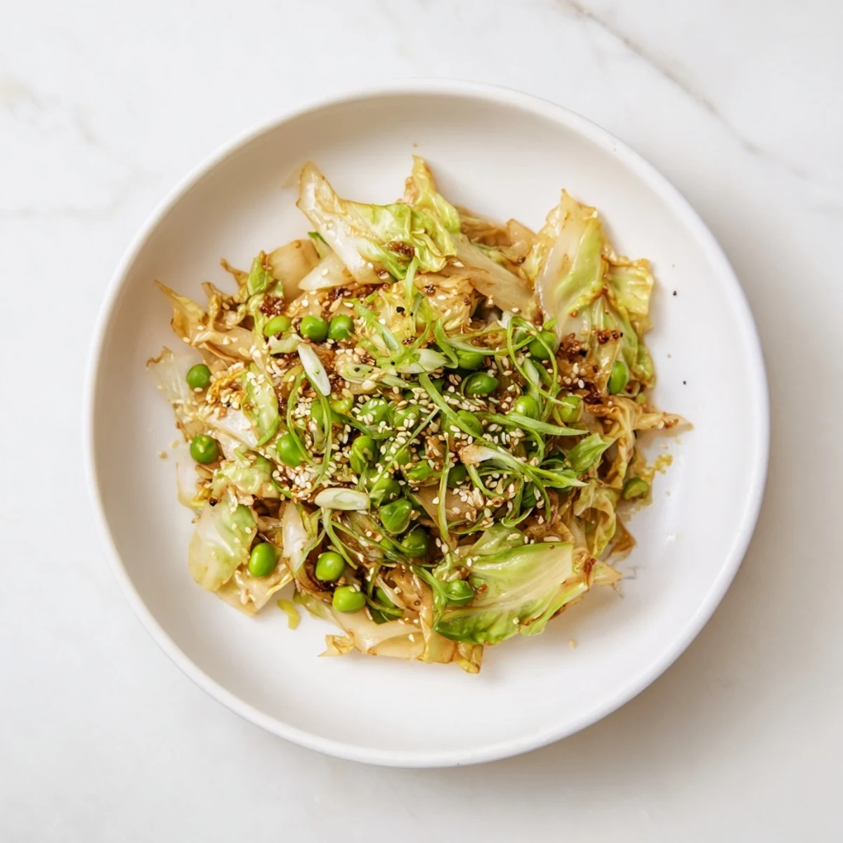 Steaming Cabbage Stir-Fry with Garlic and Soy sauce is ready—a colorful side dish with vibrant peas.