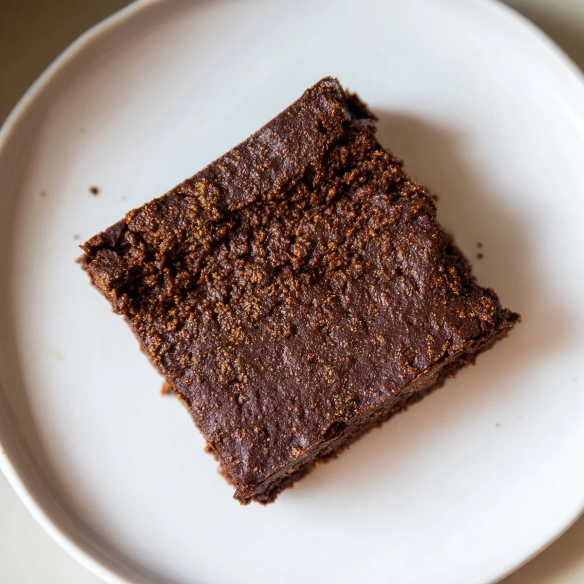 Fudgy Pumpkin Workout Brownies, pictured with a dusting of cocoa and ready to enjoy as a healthy treat.