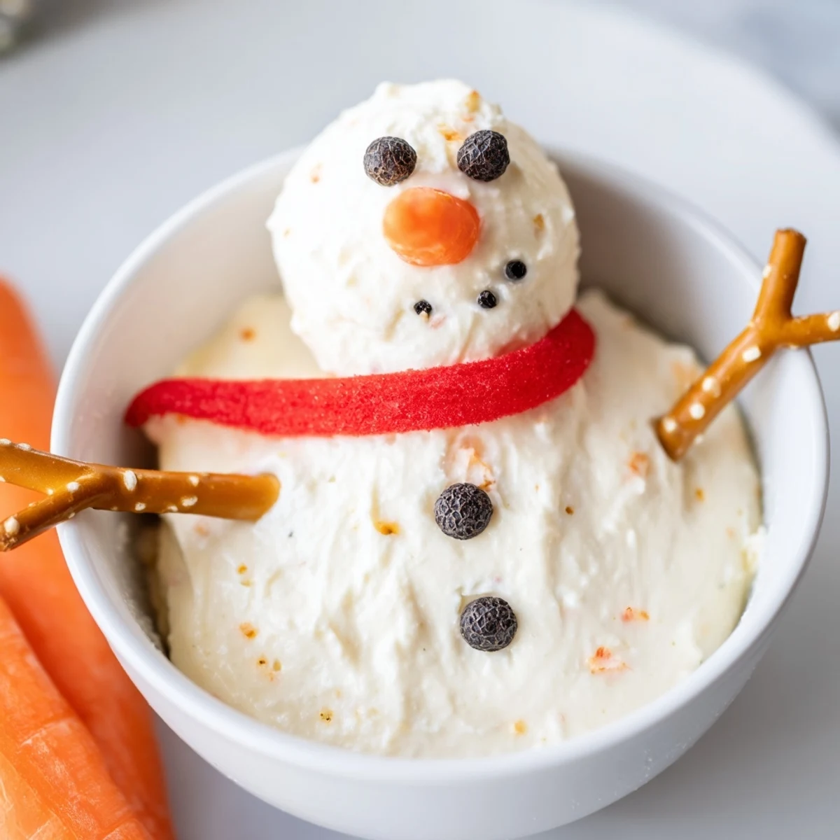 A close-up of the delightful Snowman Dip, showing a melted form with bell pepper scarves and veggie dippers.