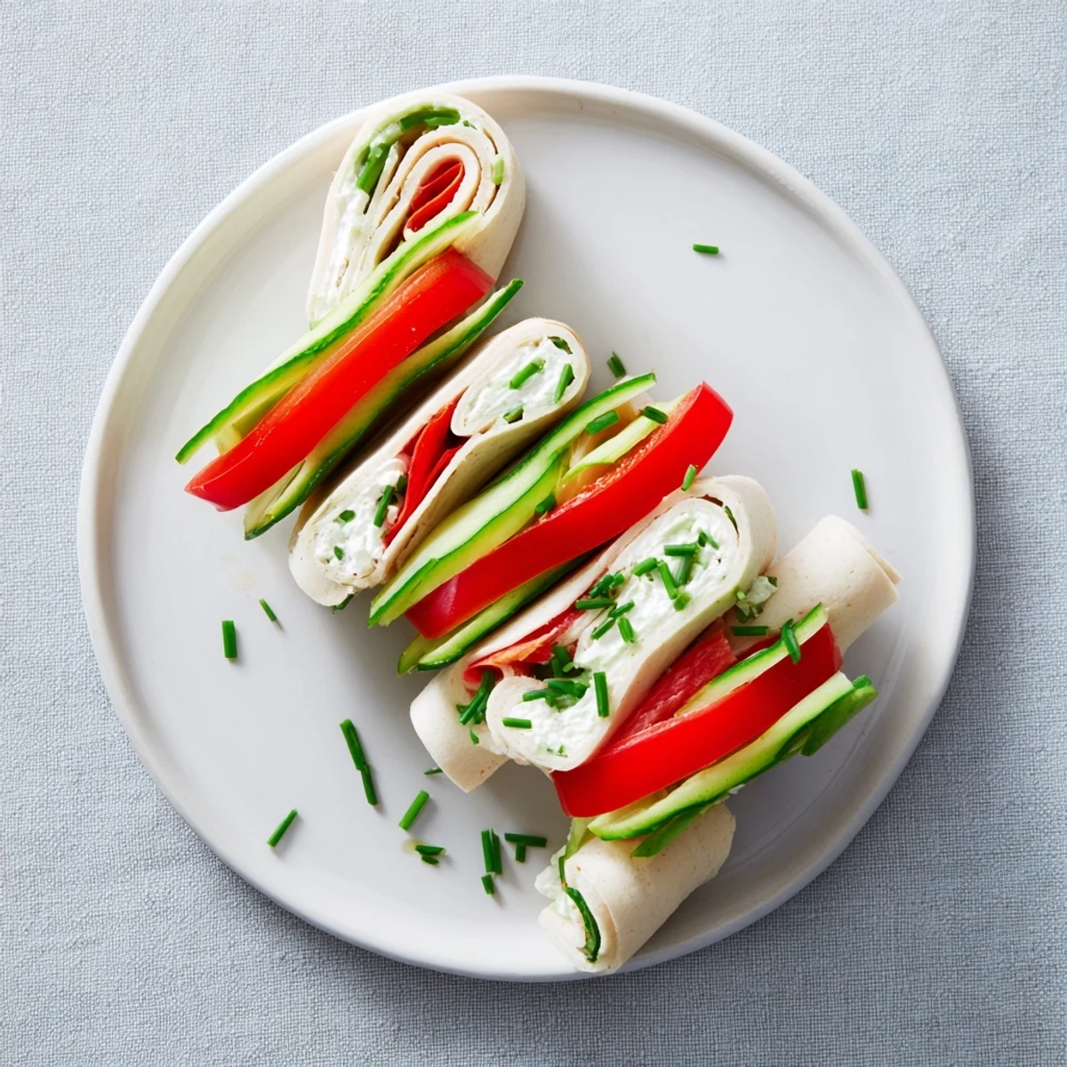 Perfectly rolled turkey roll-ups, showcasing optional cream cheese filling and fresh chive garnish in this photo.