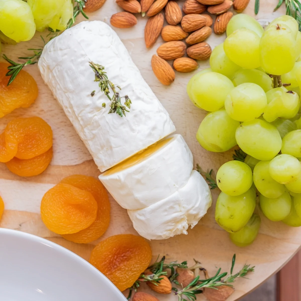 Elegant Book Club Pairing Platter, showcasing creamy cheeses, fresh fruit, and fragrant rosemary sprigs.