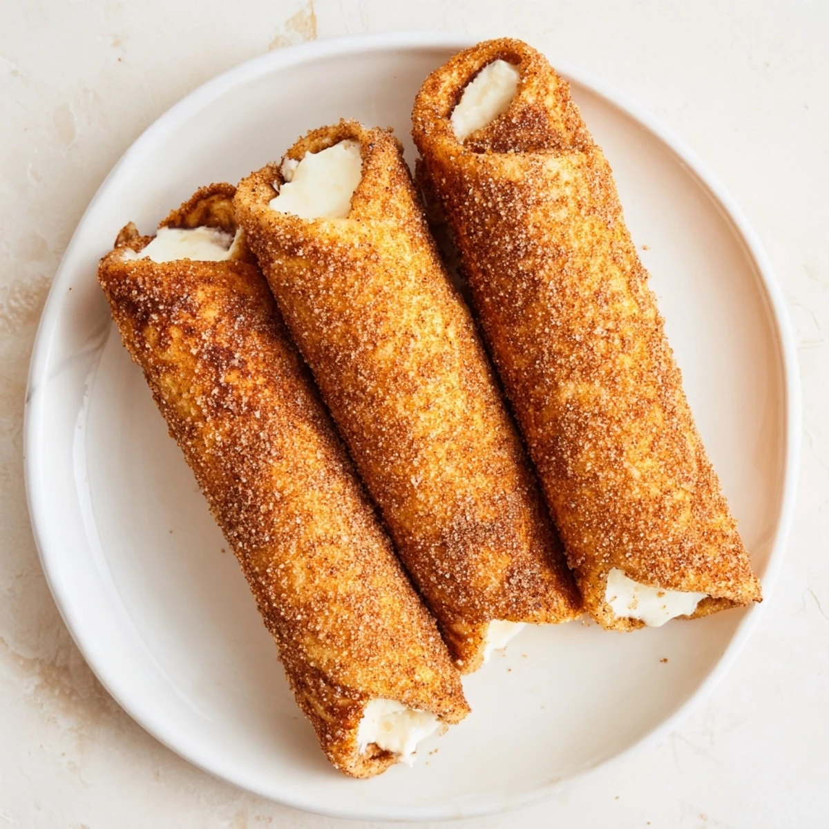 Golden, cinnamon-sugar-dusted Easy French Toast Roll-Ups, perfect for a quick breakfast snack, warm and sweet.