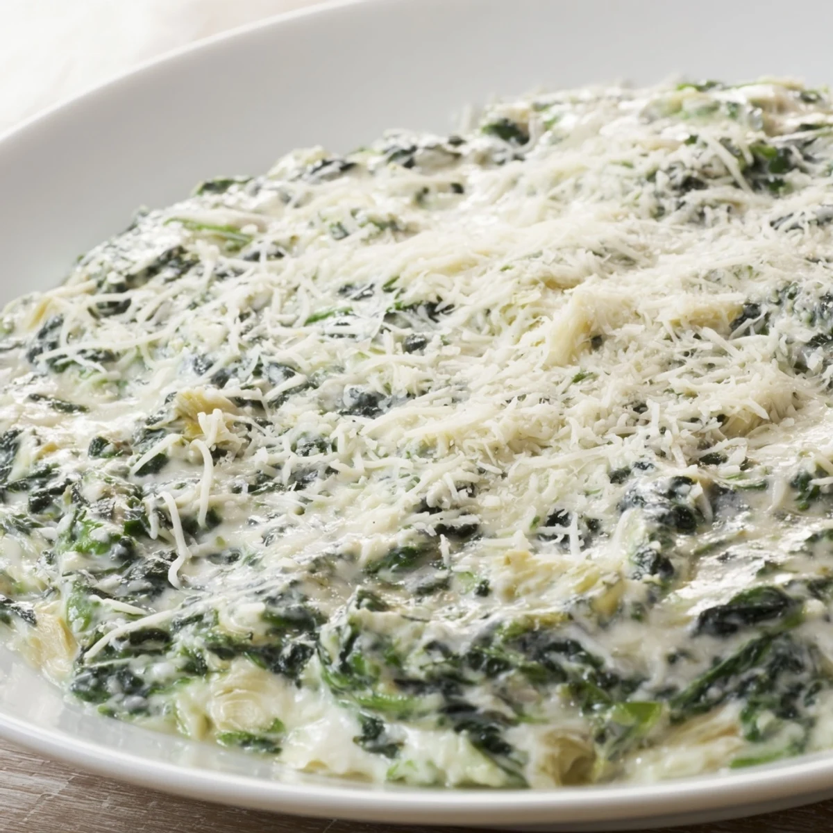 Golden-brown, cheesy Spinach Artichoke Dip, ready to be scooped up and enjoyed with friends.