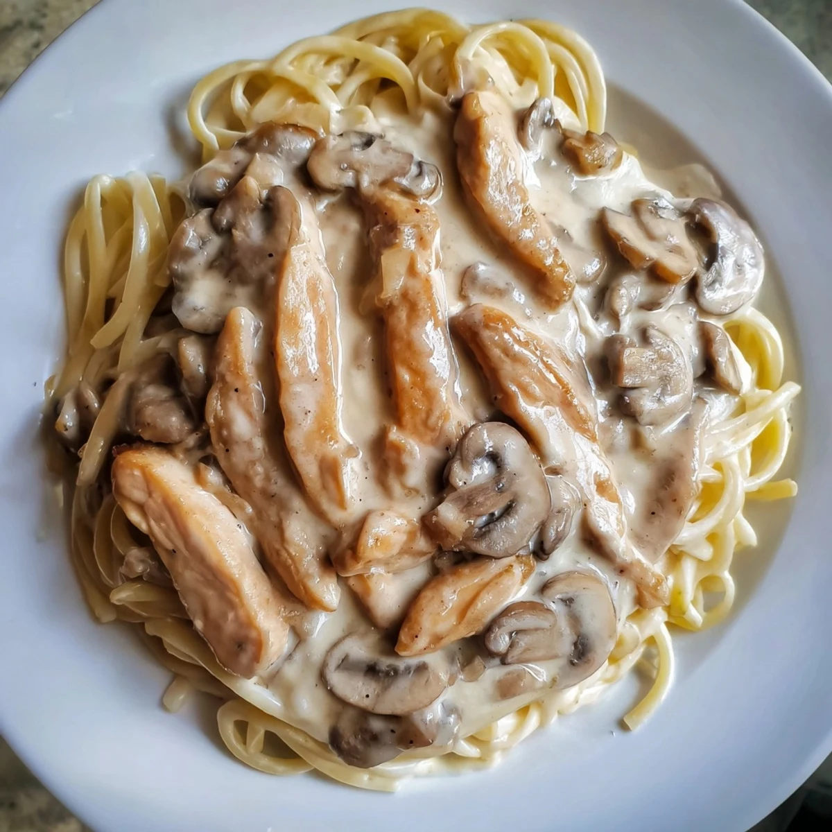 Savory Cremini mushrooms and sautéed onions simmered in a light, creamy sauce, enveloping whole wheat spaghettini and slices of juicy, seared chicken breast.