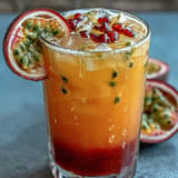 Refreshing Tropical Sunrise Mocktail, vibrant orange and passionfruit juices chilled.