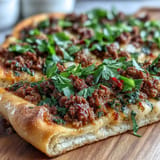 Savory lamb-topped Turkish Lahmacun Pizza, ready to be garnished with fresh herbs.