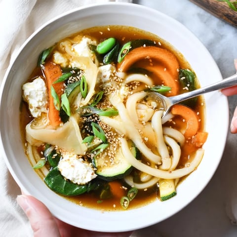 Hearty Sweet Soy Udon Lasagne Soup garnished with sesame seeds and green onions.  