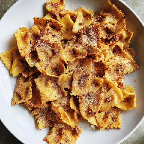 Crispy pasta chips seasoned with garlic and smoked paprika, perfect for snacking.  