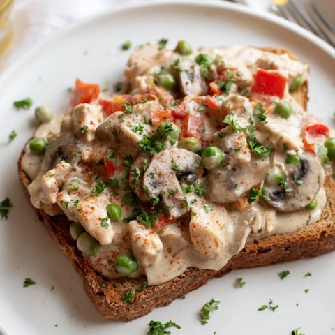 Creamy chicken à la king spooned over perfectly toasted bread, a comforting American classic.