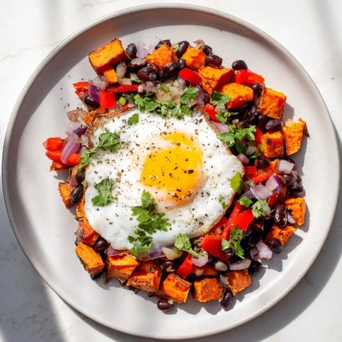 Golden-brown Sweet Potato & Black Bean Breakfast Hash, topped with perfectly poached eggs, ready to enjoy.