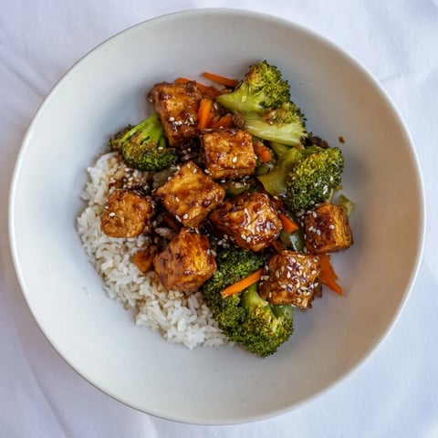 Golden sesame tofu and broccoli glistens alongside fluffy rice in this inviting Asian-inspired dish.