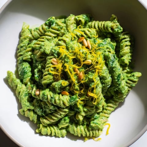 A bowl of Green Pea & Spinach Elf Green Protein Pasta, swirling with a creamy, vibrant green sauce.