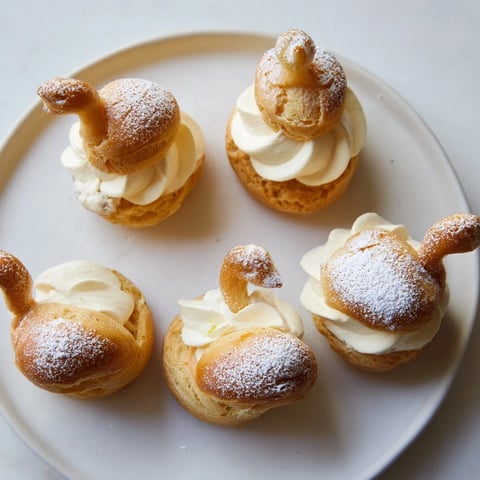 Elegant Feathered Friend Swan Pastry Platter featuring golden swan-shaped cream puffs, dusted in powdered sugar.
