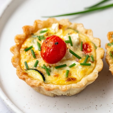 Golden-brown Couronne Florale Mini Quiches, arranged in a pretty floral wreath, ready to be served.