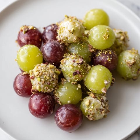 Vibrant Sparkling Grape Cluster Appetizer, garnished with edible glitter and fresh mint, ready to serve.