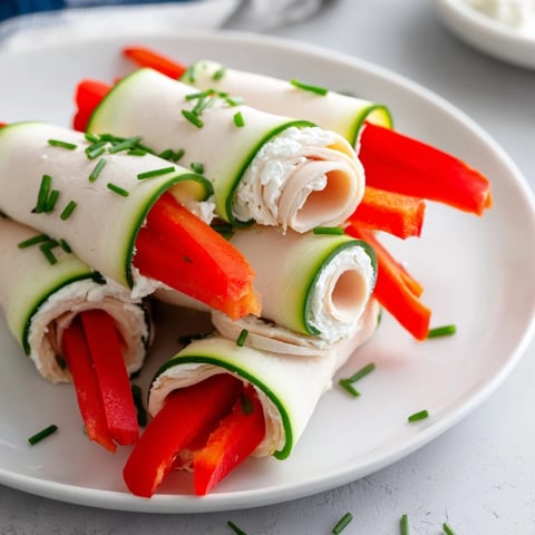 Stacked turkey roll-ups, vibrant with red pepper and cucumbers, a quick, easy appetizer ready to serve.