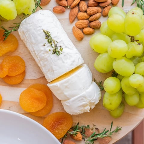 Elegant Book Club Pairing Platter, showcasing creamy cheeses, fresh fruit, and fragrant rosemary sprigs.