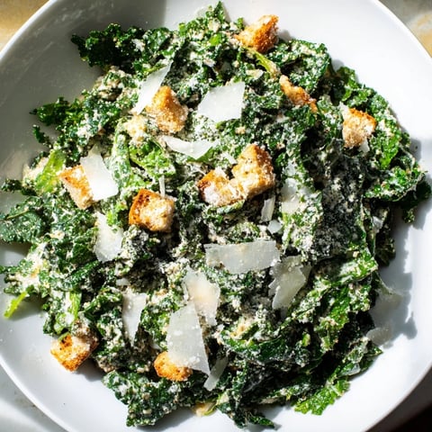 Vibrant Kale Caesar Salad with golden croutons and shaved Parmesan, a delicious vegetarian meal.