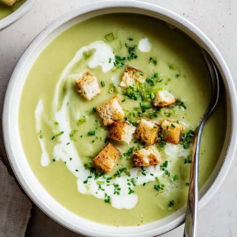 Creamy Broccoli Soup in a rustic bowl, topped with croutons and chives, perfect for a comforting vegetarian lunch.