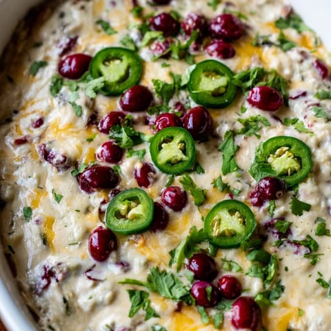Vibrant cranberry jalapeño queso dip, perfect for game day celebrations and gatherings.  