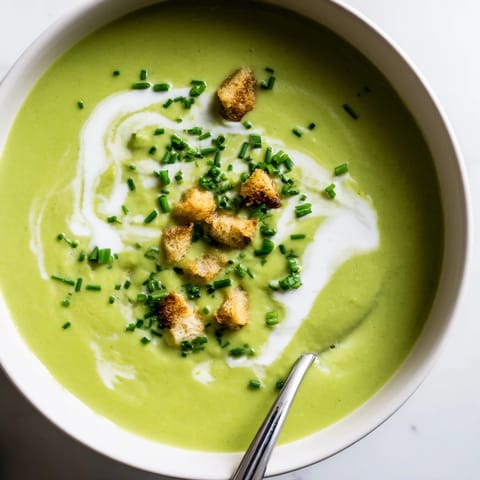 A rich, velvety Creamy Broccoli Soup served hot, garnished with a swirl of heavy cream and black pepper.