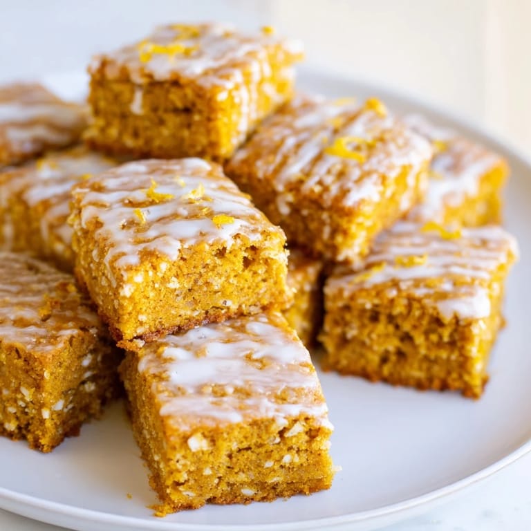 Aromatic pumpkin cake squares infused with fresh ginger and lemon, topped with a sweet glaze.  