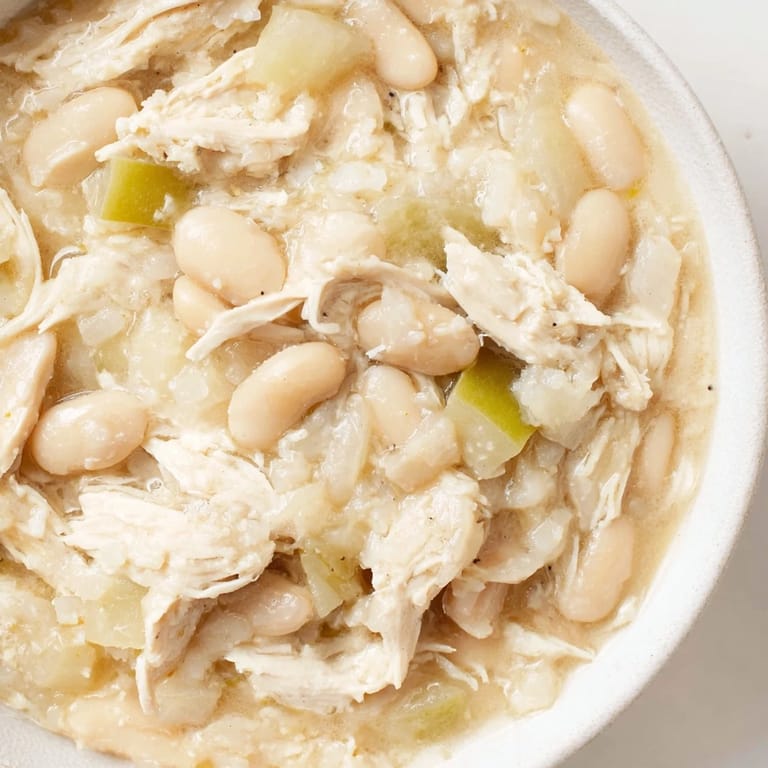 Close-up of a bubbling pot of 35-Minute White Cheddar Apple Chicken Chili, showcasing the delicious, cheesy broth.