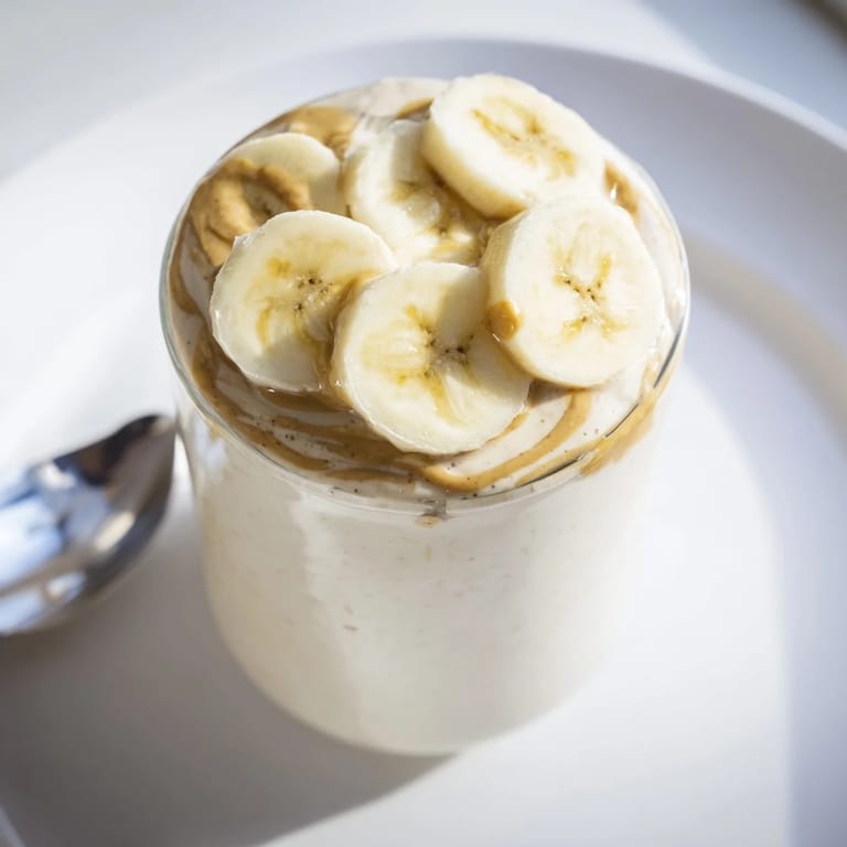 Freshly blended peanut butter banana smoothie, a cool, refreshing breakfast, perfect for a quick, healthy boost.