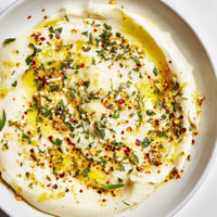 Golden, glistening Cowboy Butter Sauce, ready to be drizzled over grilled steak, with herbs on top.