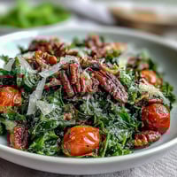 Fresh dandelion greens salad with lemon vinaigrette and Parmesan, topped with cherry tomatoes and toasted pine nuts for a bright, zesty dish.